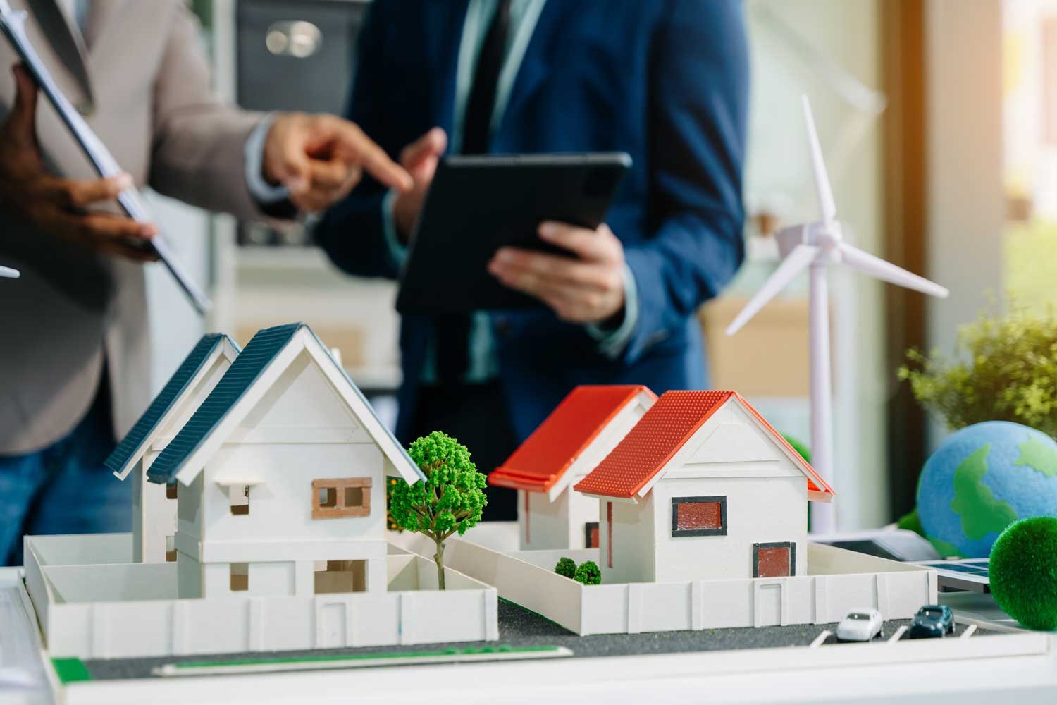 dos personas mostrando maquetas de casas, un grupo de expertos